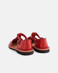 A pair of red leather flat sandals shown from the back on a light gray background.