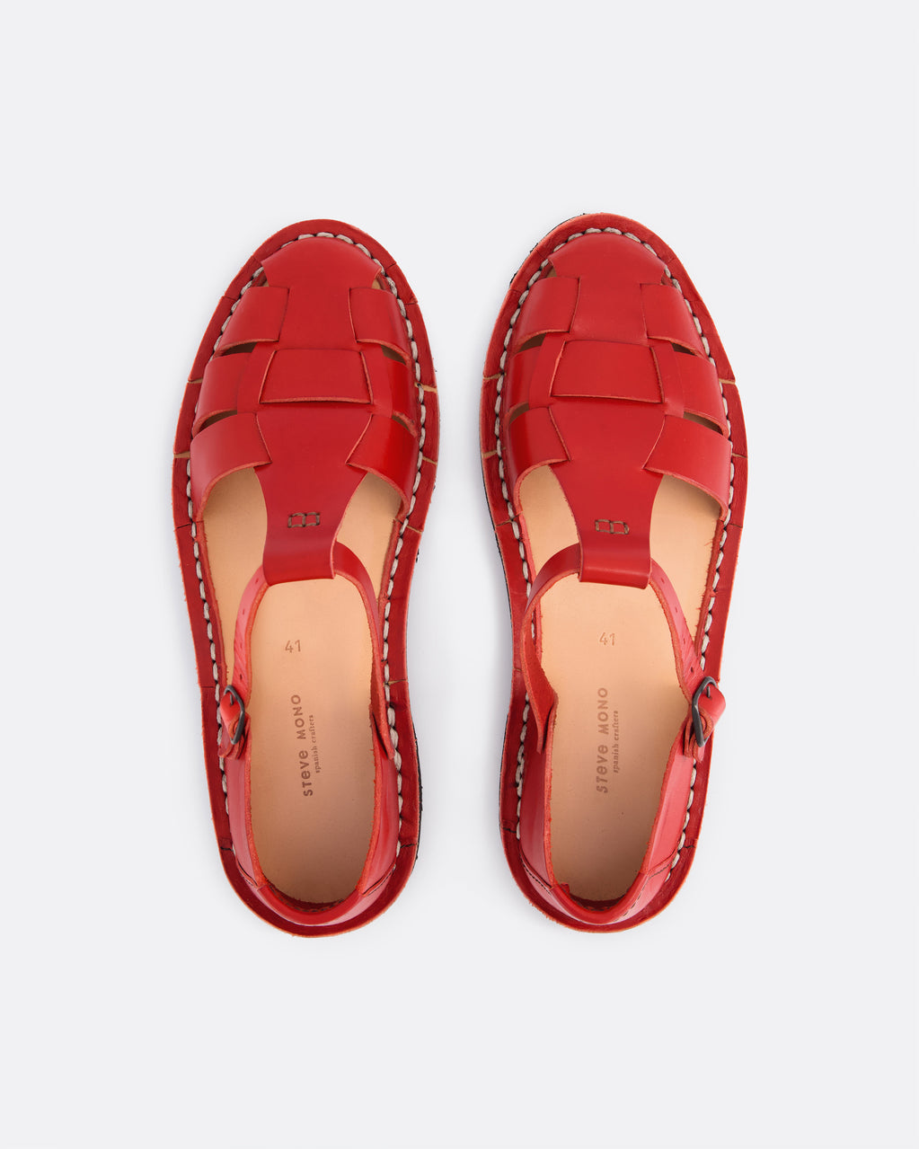 A pair of red leather woven sandals shown from a top-down view on a light gray background. The sandals feature a braided upper, contrast stitching, and a light tan insole with the brand name 'STEVE MONO' printed on it.
