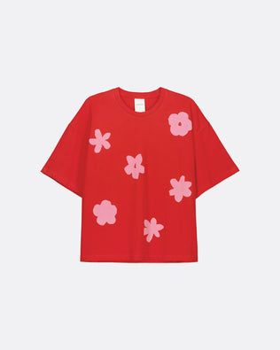 A red short-sleeve t-shirt with a pattern of light pink abstract flower shapes, displayed flat against a light gray background.