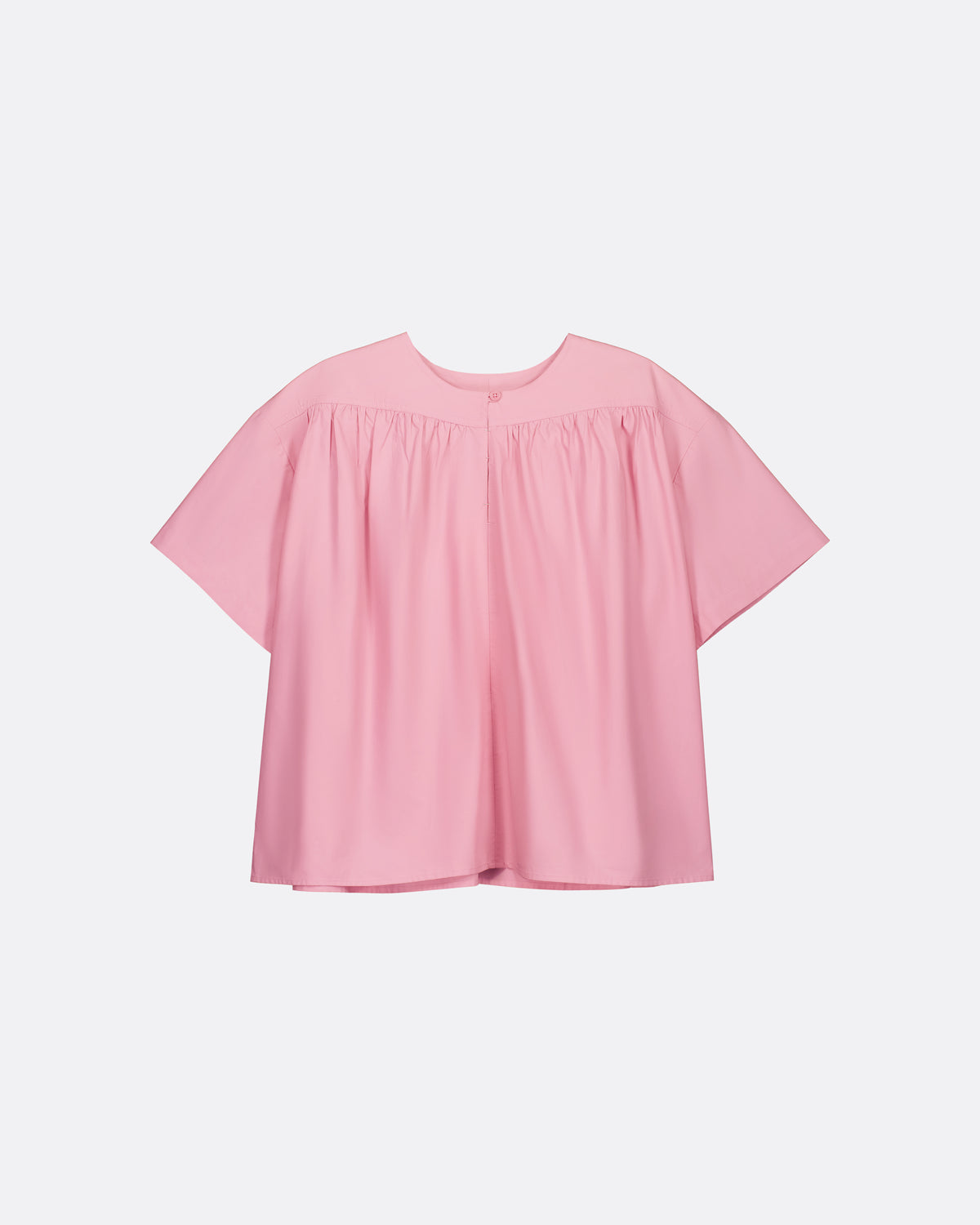 A light pink short-sleeve blouse with a gathered, smocked bodice and a relaxed, oversized silhouette, shown against a plain light gray background.