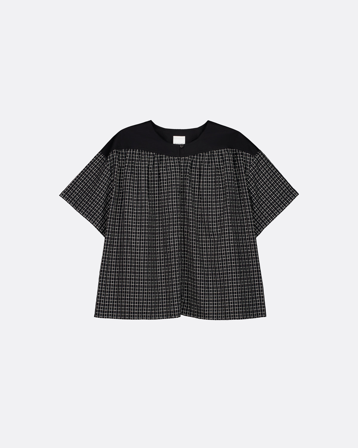 A short-sleeve top with a solid black yoke and a black-and-white micro-check patterned body, displayed flat against a light gray background.
