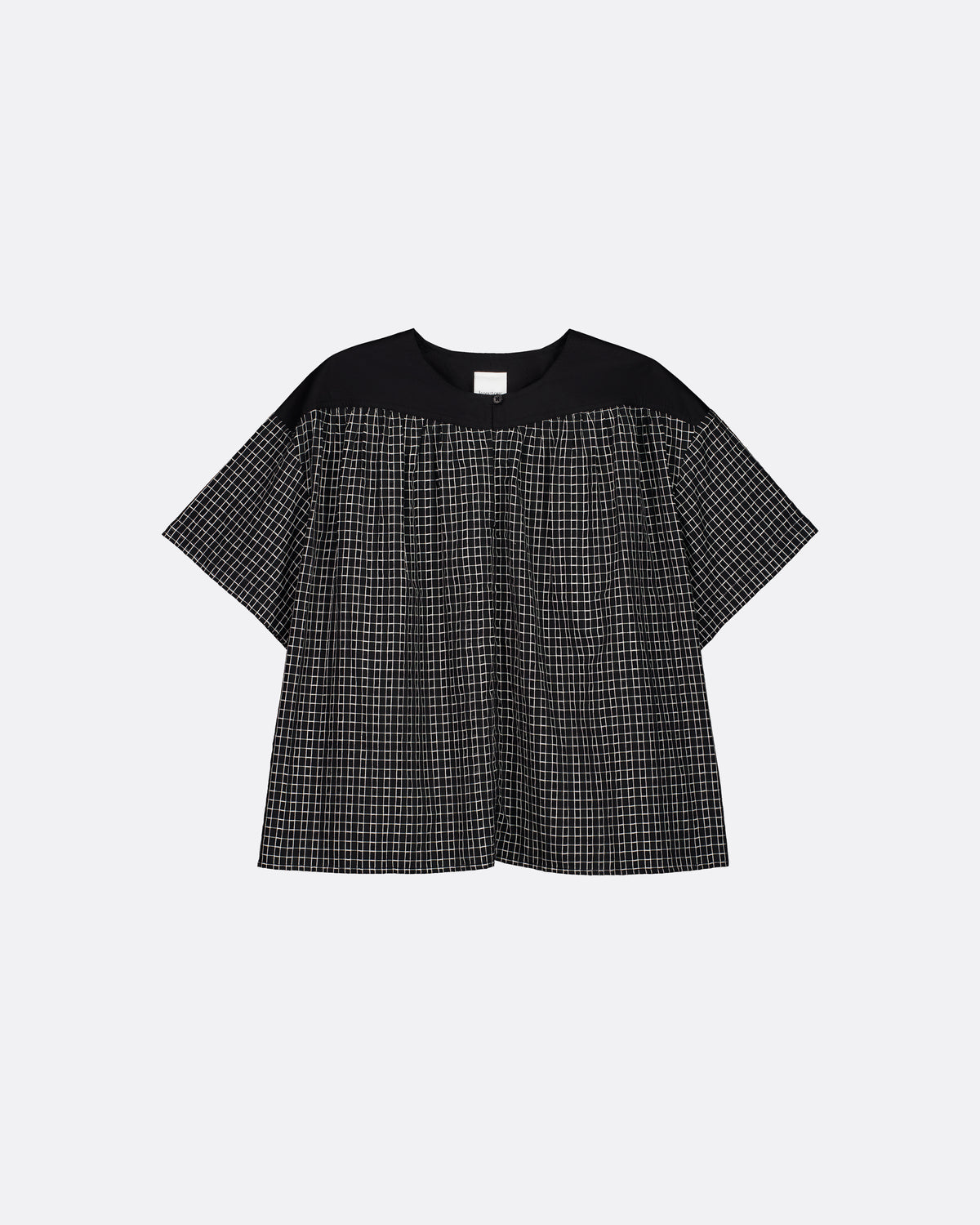 A short-sleeve top with a solid black yoke and a black-and-white micro-check patterned body, displayed flat against a light gray background.