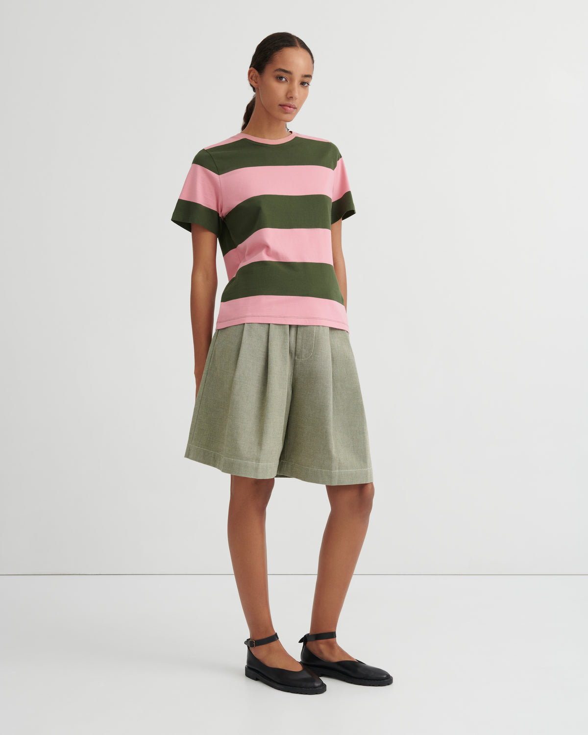 Woman wearing a striped shirt and skirt on a white background