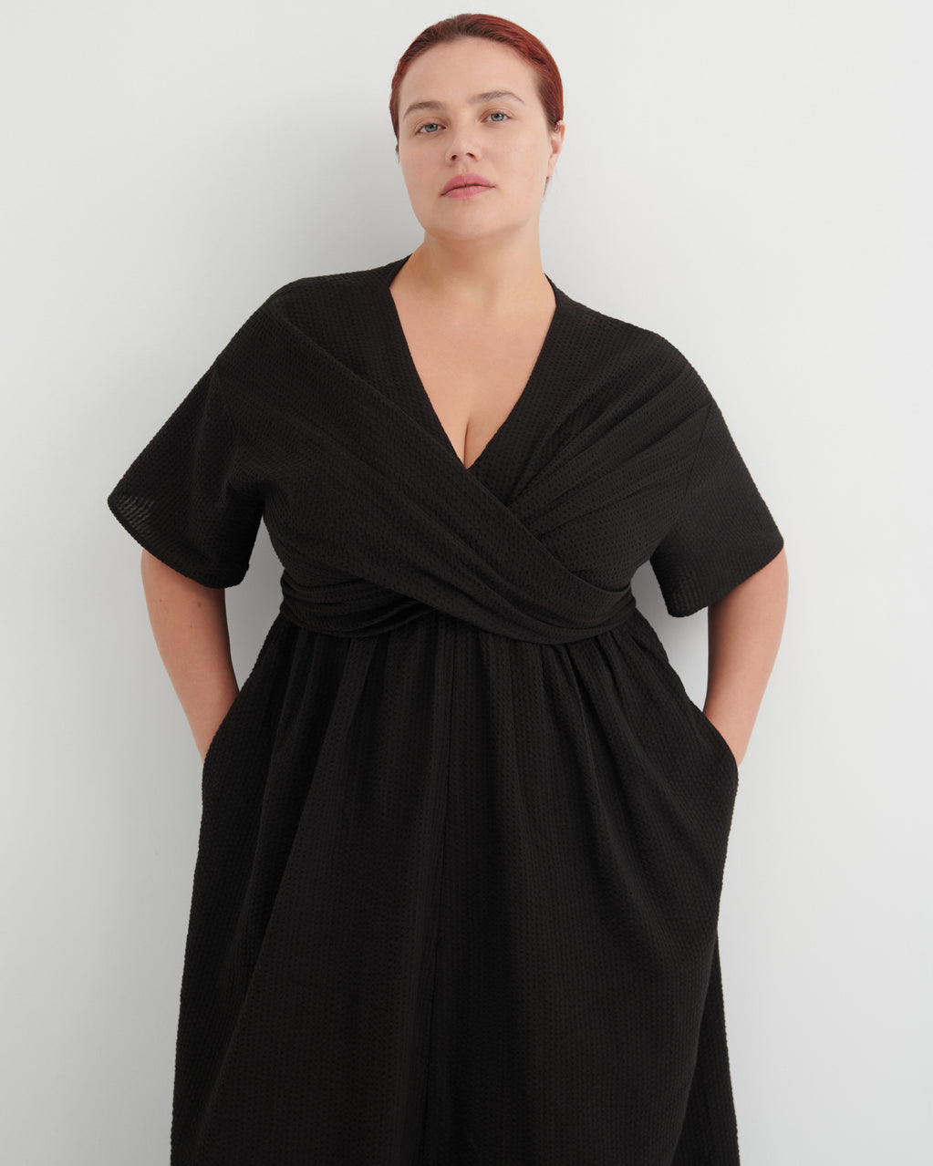 Woman wearing a black dress against a white background