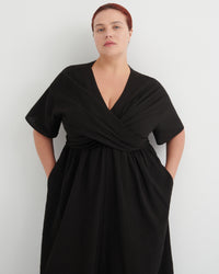 Woman wearing a black dress against a white background