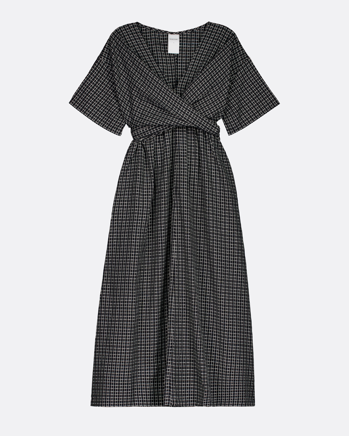 A short-sleeve midi dress with a black and white micro-check pattern, featuring a wrap-style V-neckline and a matching fabric tie belt at the waist, shown against a light gray background.