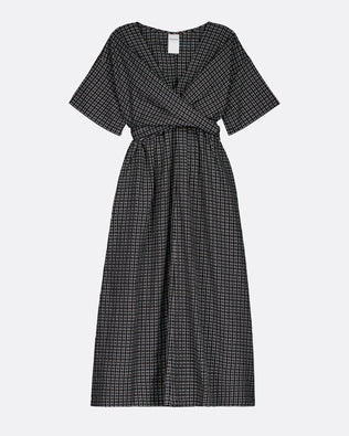A short-sleeve midi dress with a black and white micro-check pattern, featuring a wrap-style V-neckline and a matching fabric tie belt at the waist, shown against a light gray background.