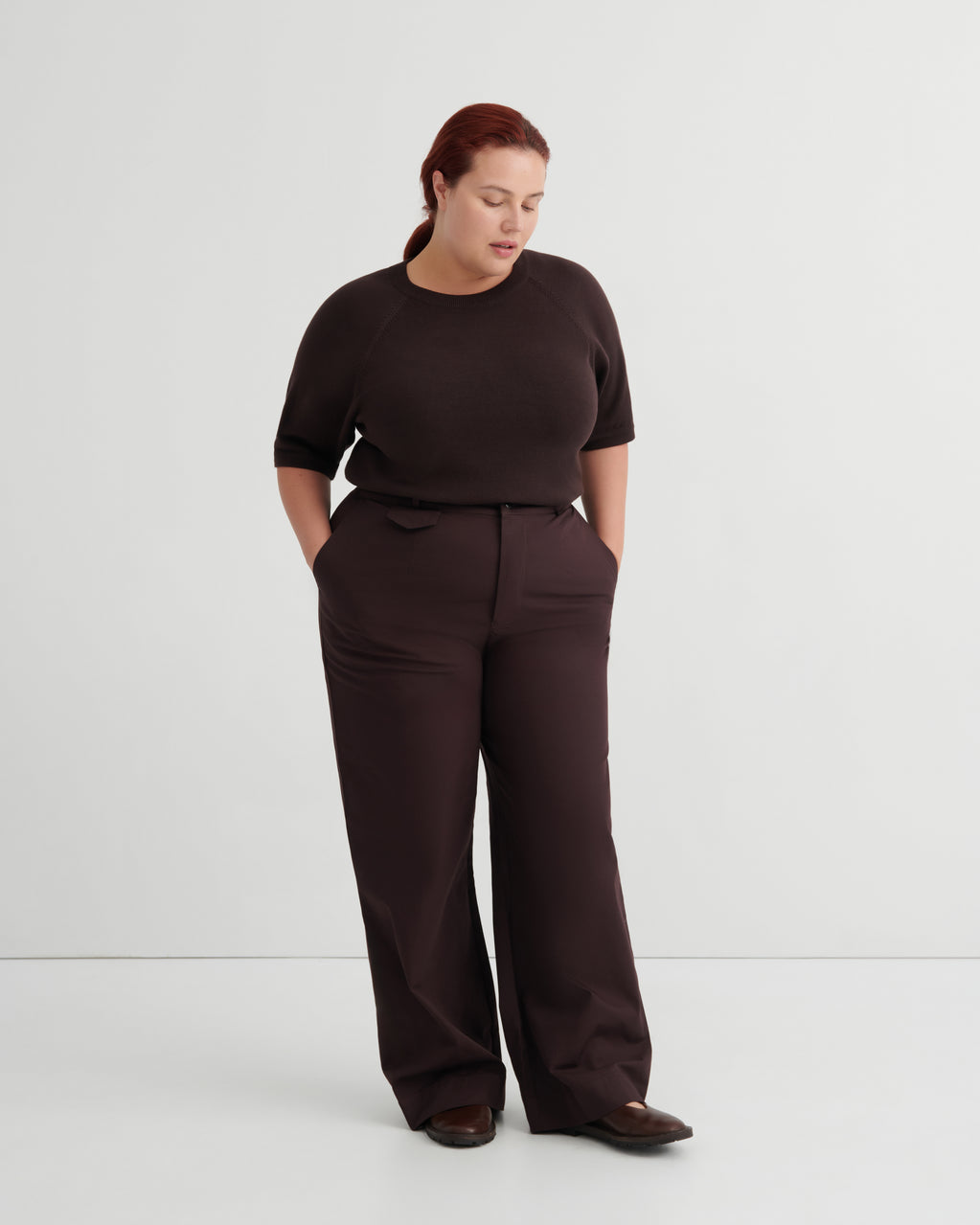 A woman modeling a dark brown short-sleeve top and matching wide-leg trousers.