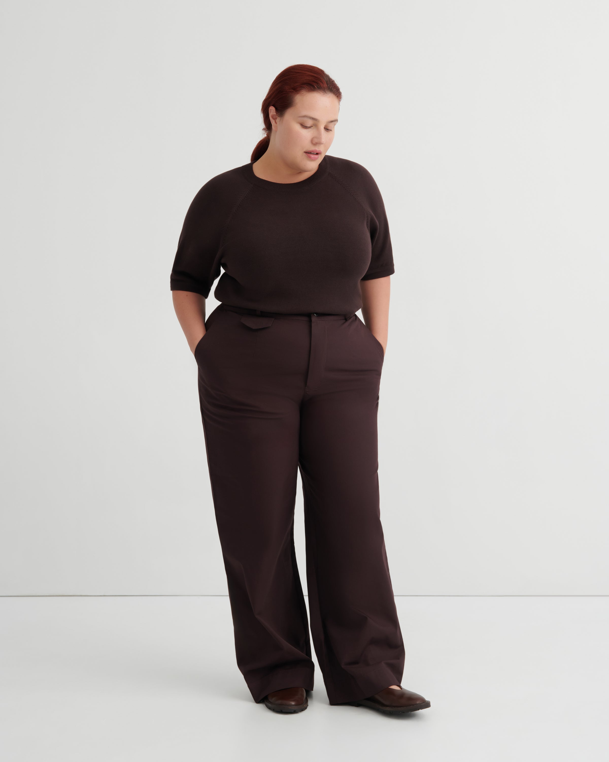 A woman modeling a dark brown short-sleeve top and matching wide-leg trousers.