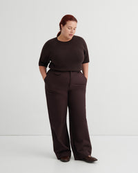 A woman modeling a dark brown short-sleeve top and matching wide-leg trousers.