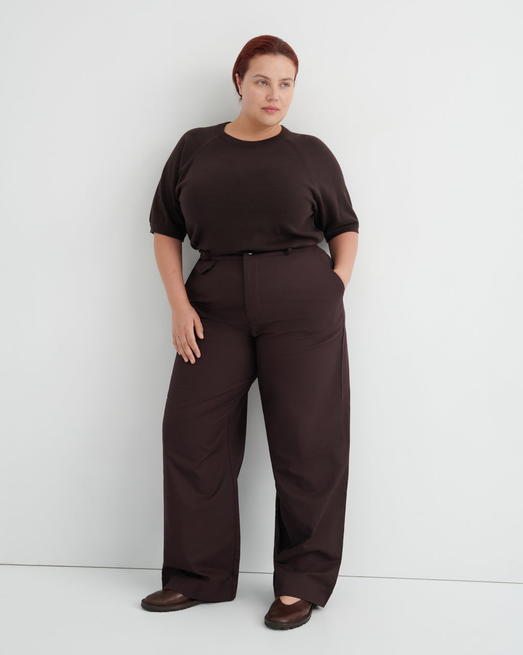 A woman modeling a dark brown short-sleeve top and matching wide-leg trousers .