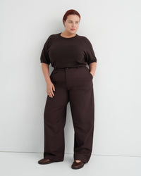 A woman modeling a dark brown short-sleeve top and matching wide-leg trousers .
