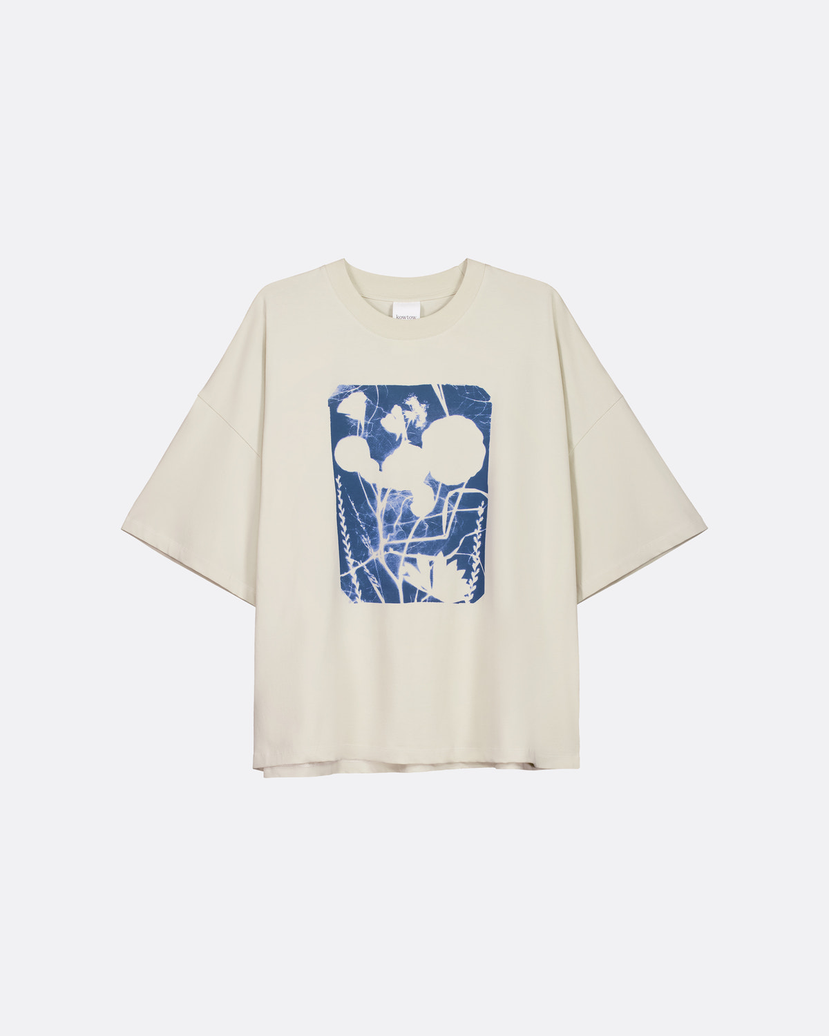 A cream-colored short-sleeve t-shirt with a blue and white abstract graphic print on the front, displayed against a light gray background.