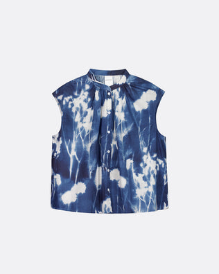 A sleeveless button-front top with a stand collar, featuring a blue and white shibori tie-dye pattern, displayed flat against a light gray background.
