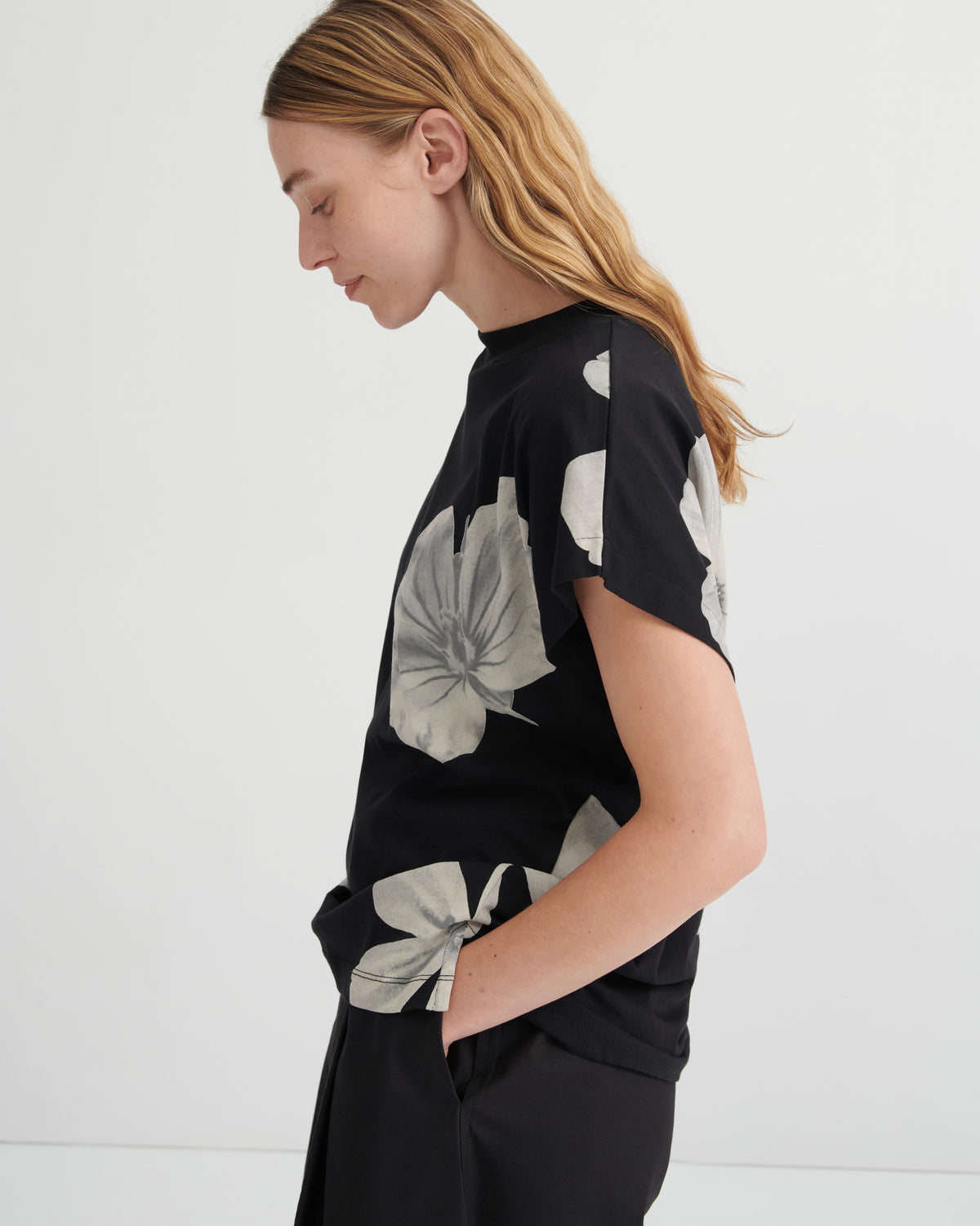 Woman wearing a black top with floral patterns against a white background