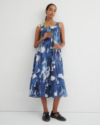 Woman wearing a blue and white floral dress against a white background