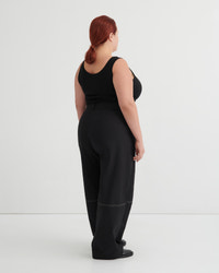 Person wearing a black tank and black pants against a white background
