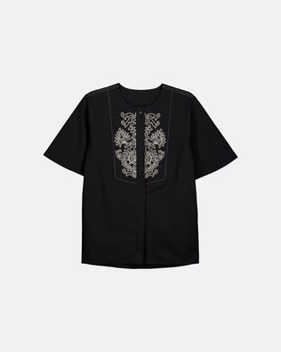 A black short-sleeve button-up shirt with ornate white embroidery on the front chest panel, displayed against a light gray background.