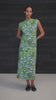 A video of a women wearing a green floral dress against a black weatherboard background.