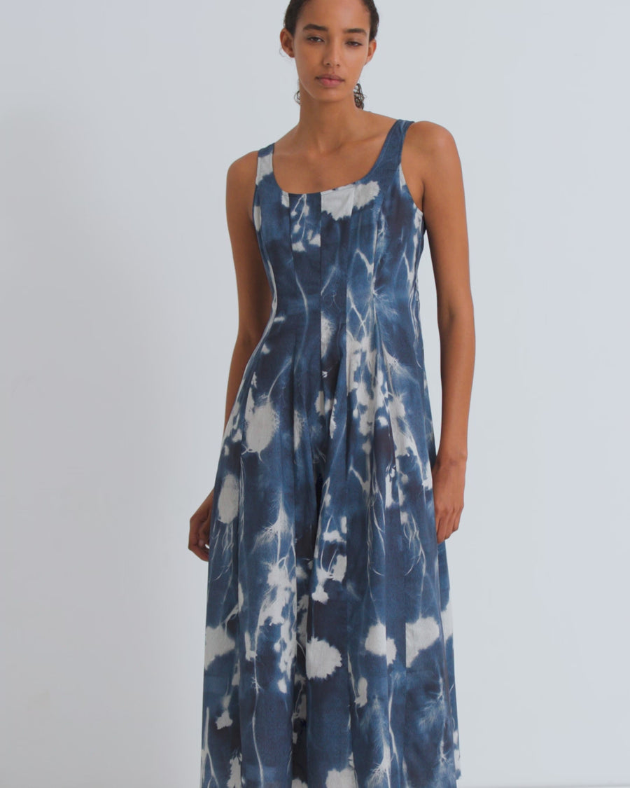 Woman wearing a blue and white floral dress against a white background