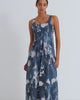 Woman wearing a blue and white floral dress against a white background