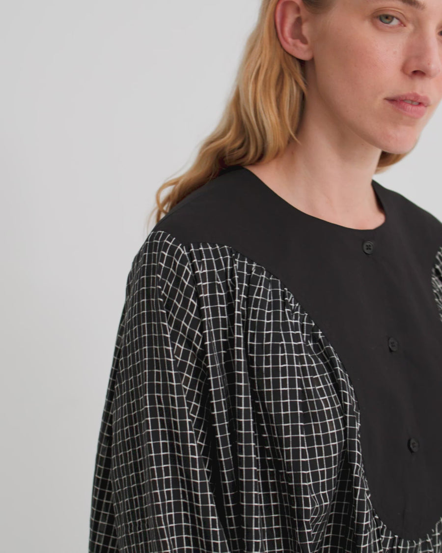 Women wearing a mini check black dress with a black yoke detail.