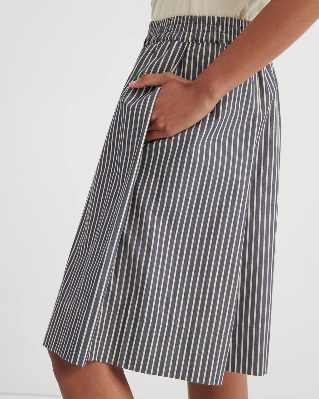 Person wearing a blue and white striped skirt on a white background