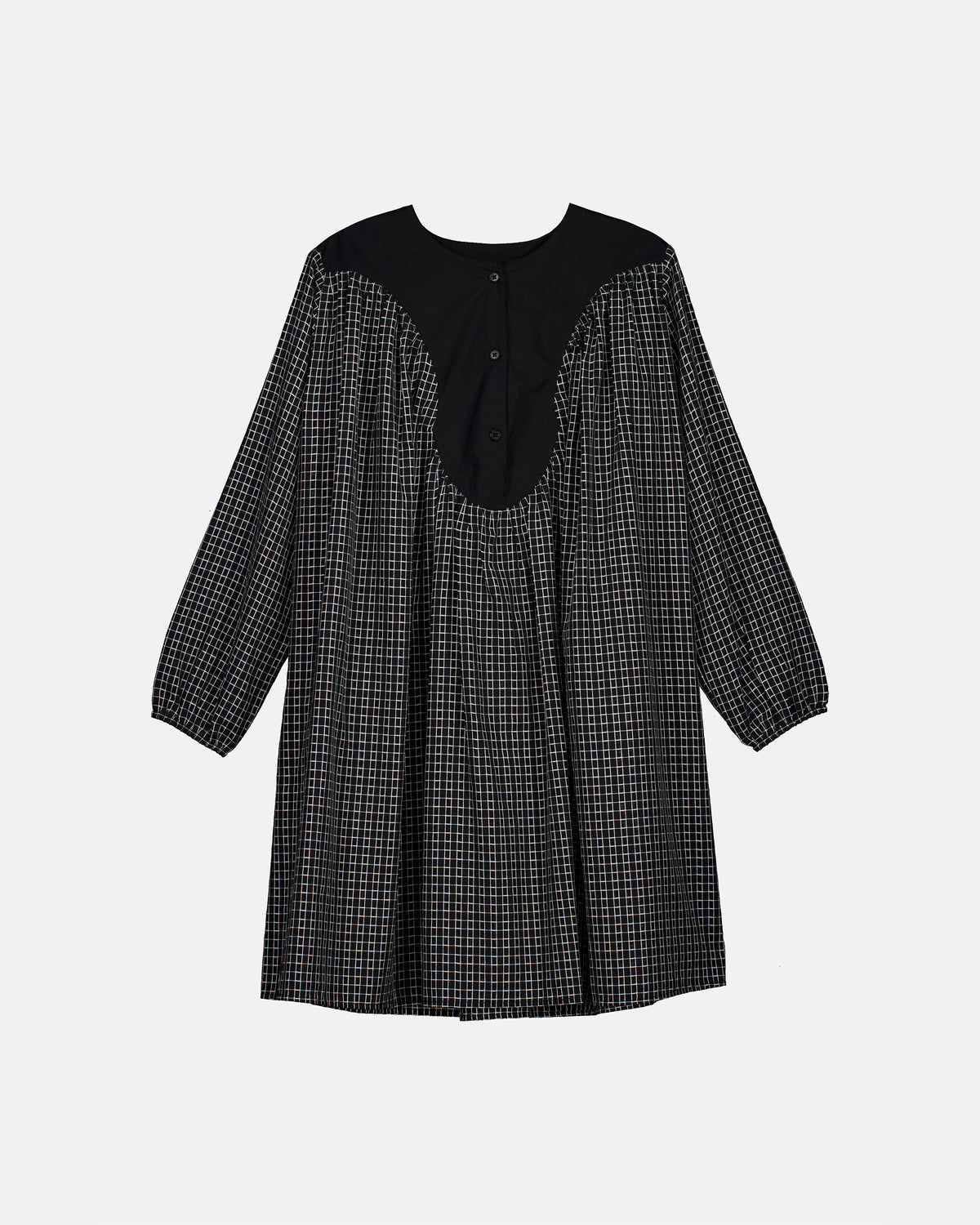 A black and white micro-check patterned long-sleeve dress with a solid black yoke and button placket, shown against a light gray background.
