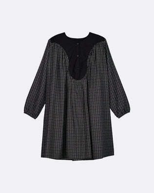 A black and white micro-check patterned long-sleeve dress with a solid black yoke and button placket, shown against a light gray background.